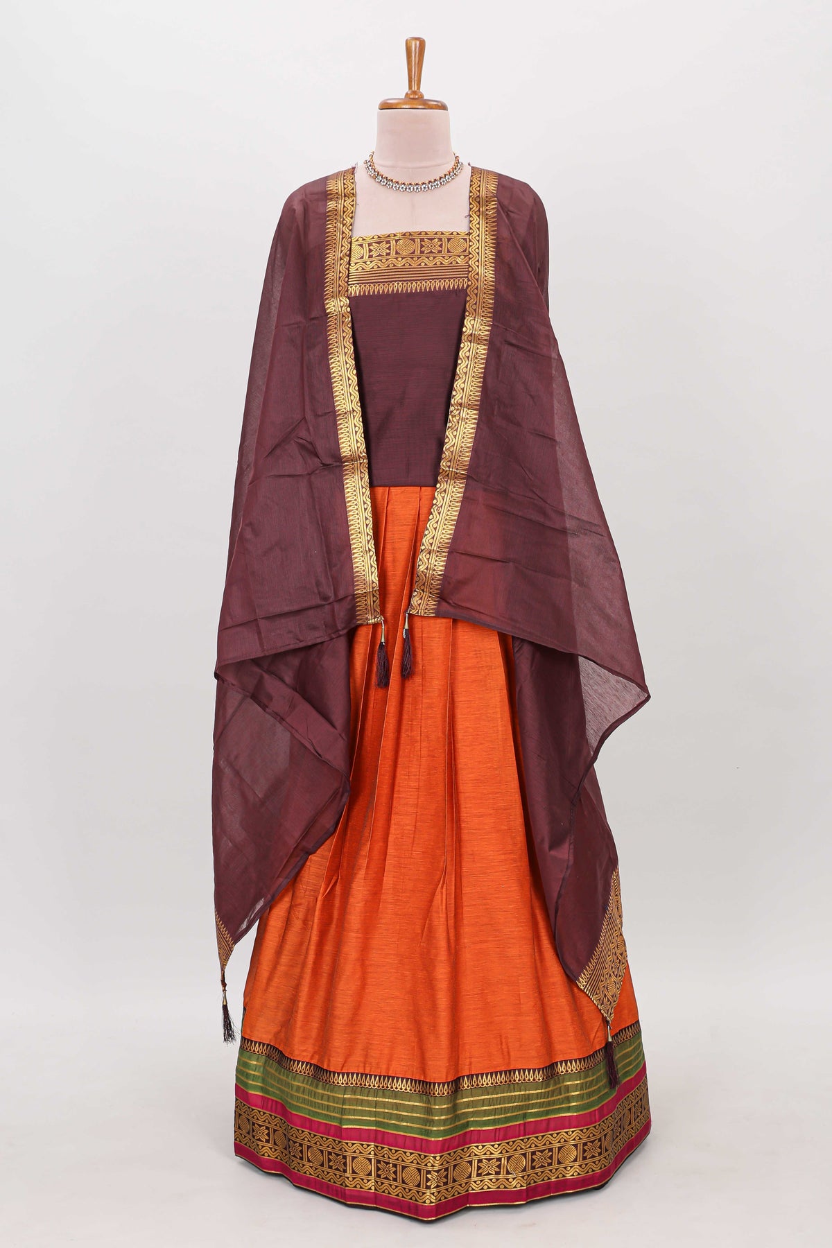 Orange shade plain lehanga featuring contrasting zari border and blouse paired with brown shawl