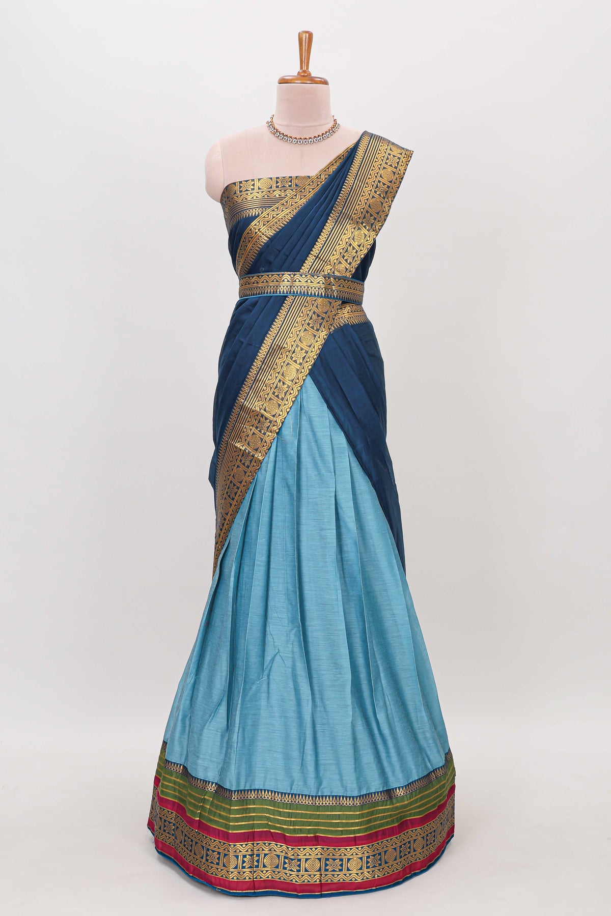 Light blue shade plain lehanga featuring contrasting zari border and blouse paired with dark blue shawl