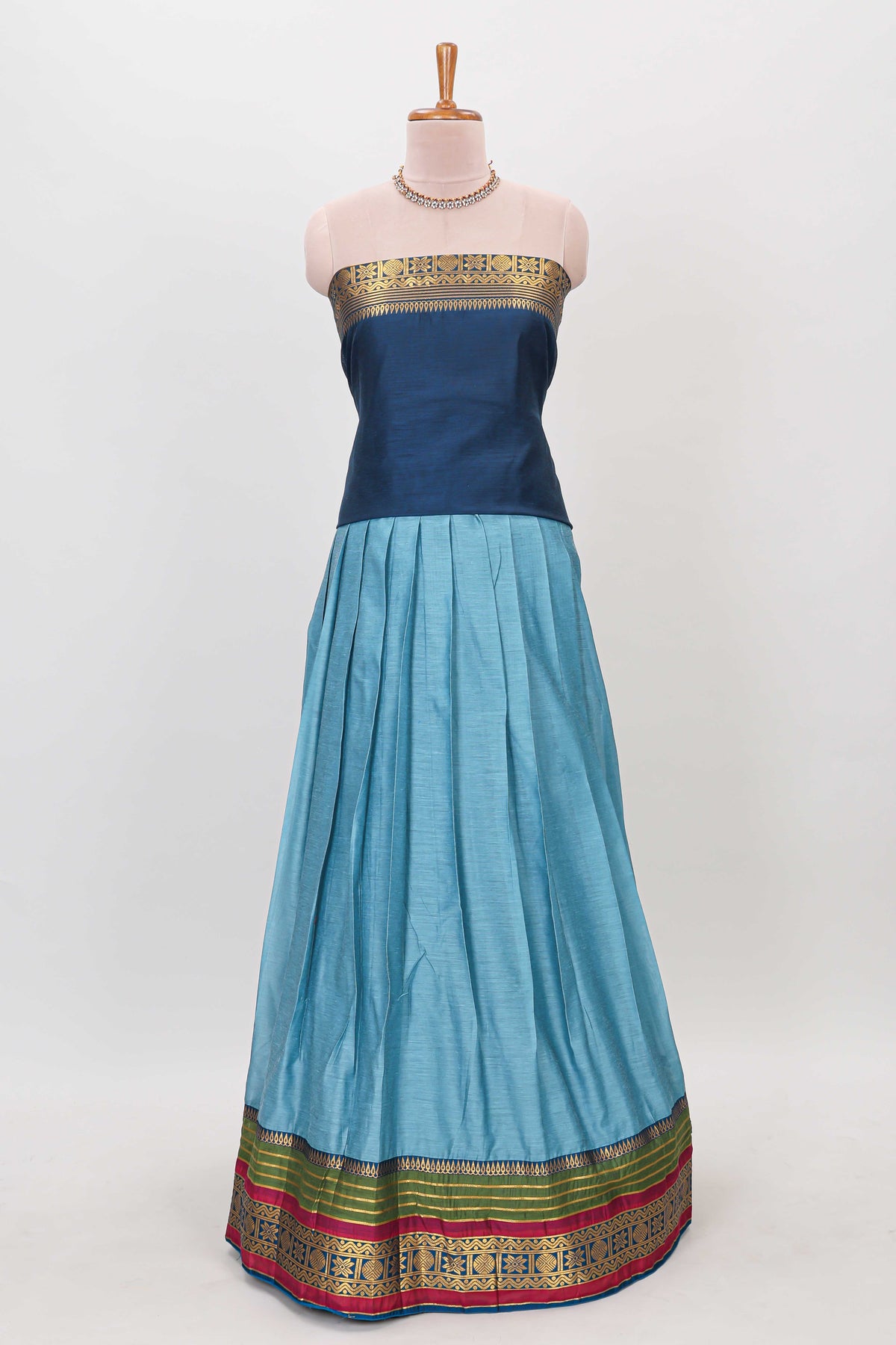 Light blue shade plain lehanga featuring contrasting zari border and blouse paired with dark blue shawl