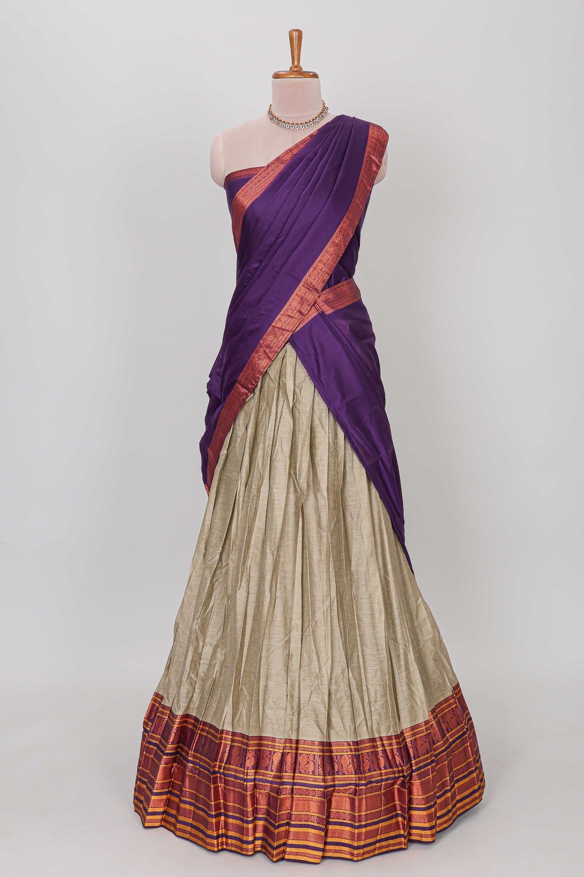 Beige shade plain lehanga featuring contrasting zari border and blouse paired with violet shawl