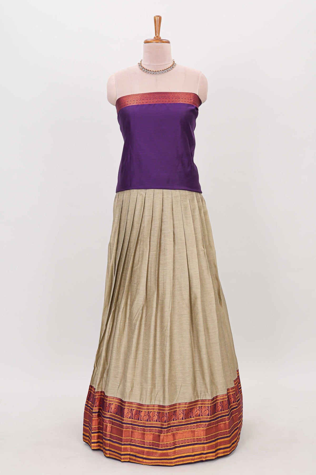 Beige shade plain lehanga featuring contrasting zari border and blouse paired with violet shawl