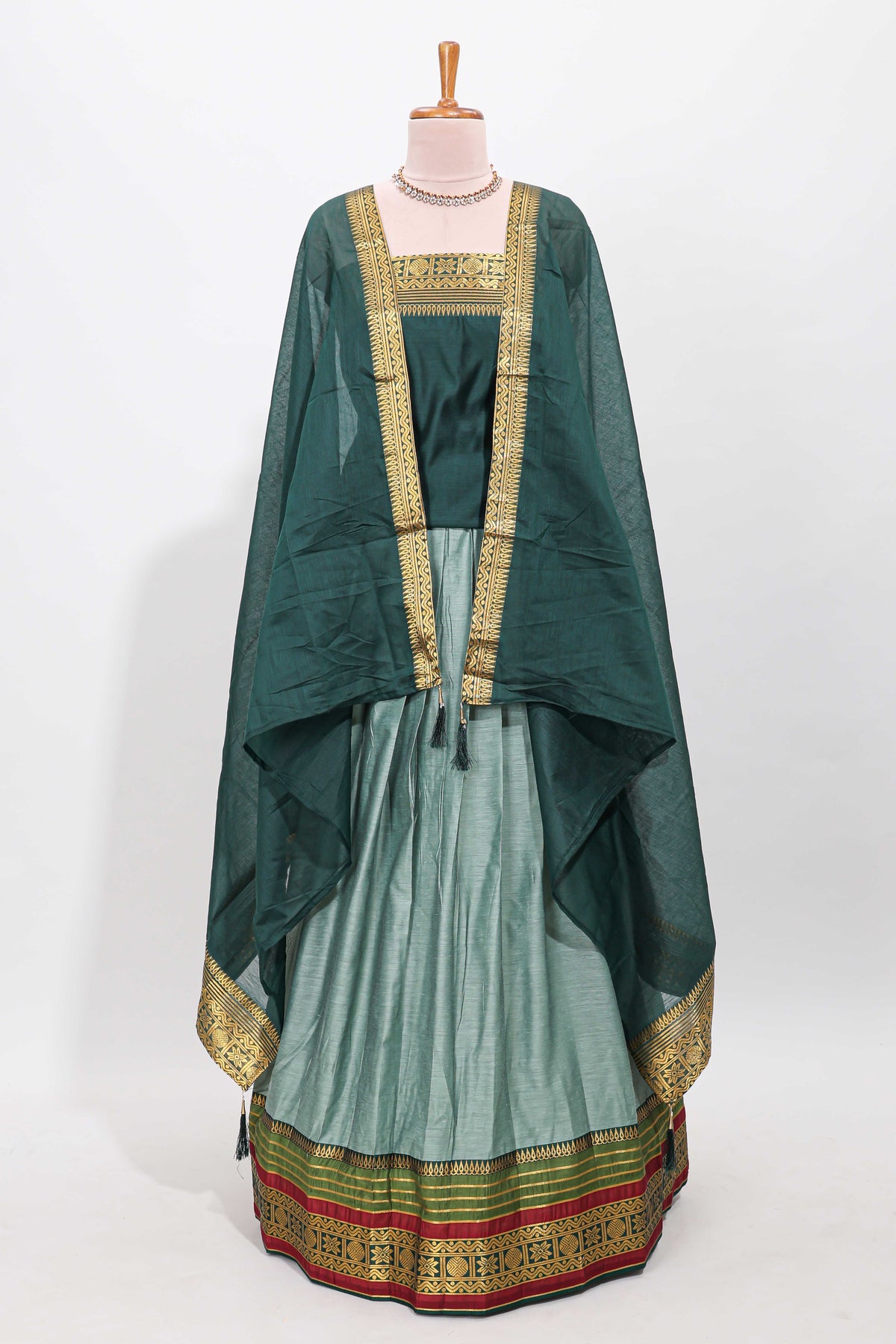 Green shade plain lehanga featuring contrasting zari border and blouse paired with pine green shawl