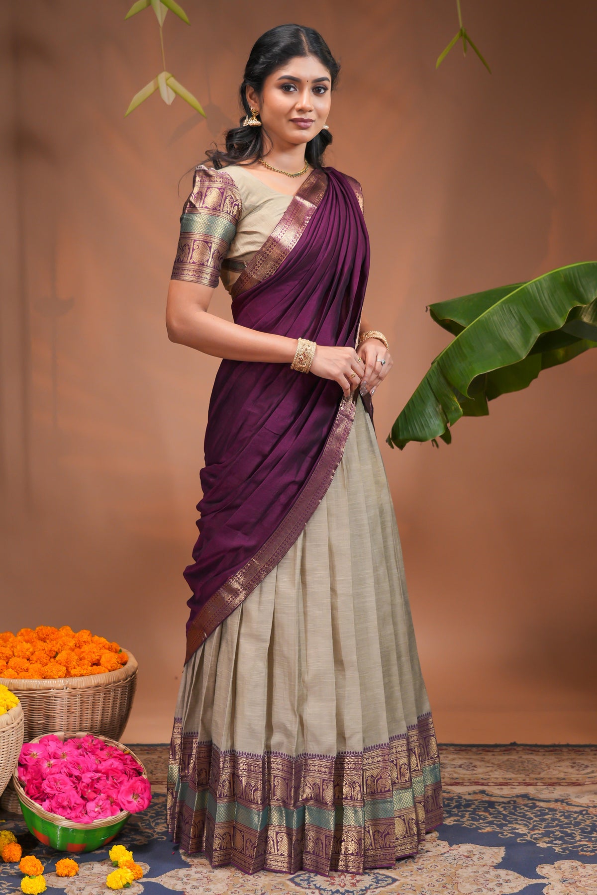 Beige plain half saree with matching blouse and contrast zari border and dhavani
