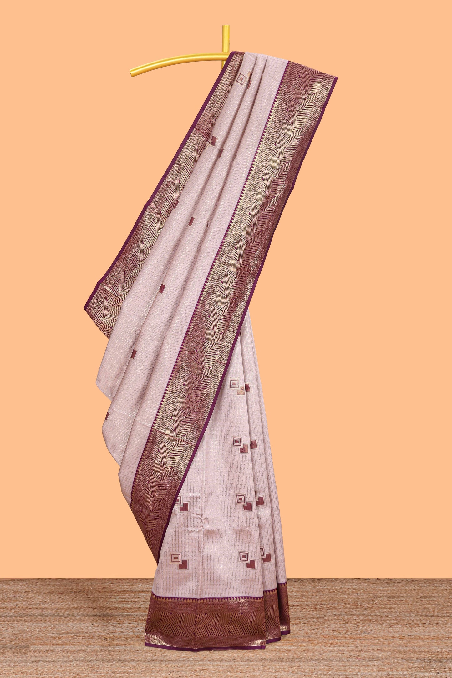 Pale pink checked geometric design litchi silk saree with contrast zari border and blouse