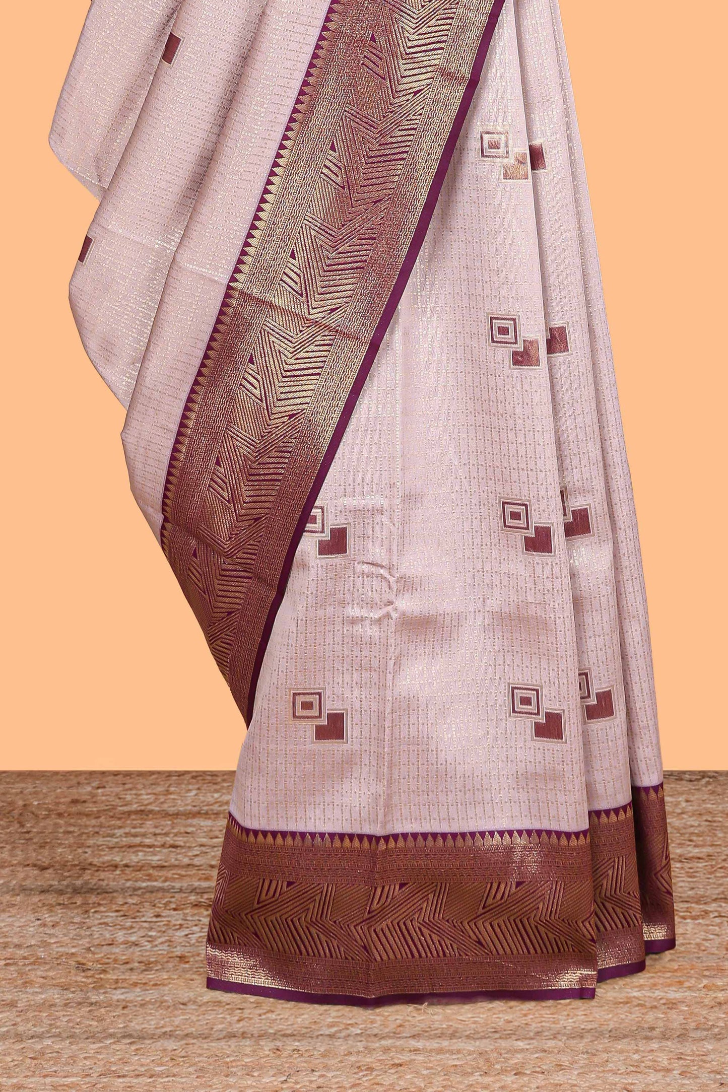 Pale pink checked geometric design litchi silk saree with contrast zari border and blouse