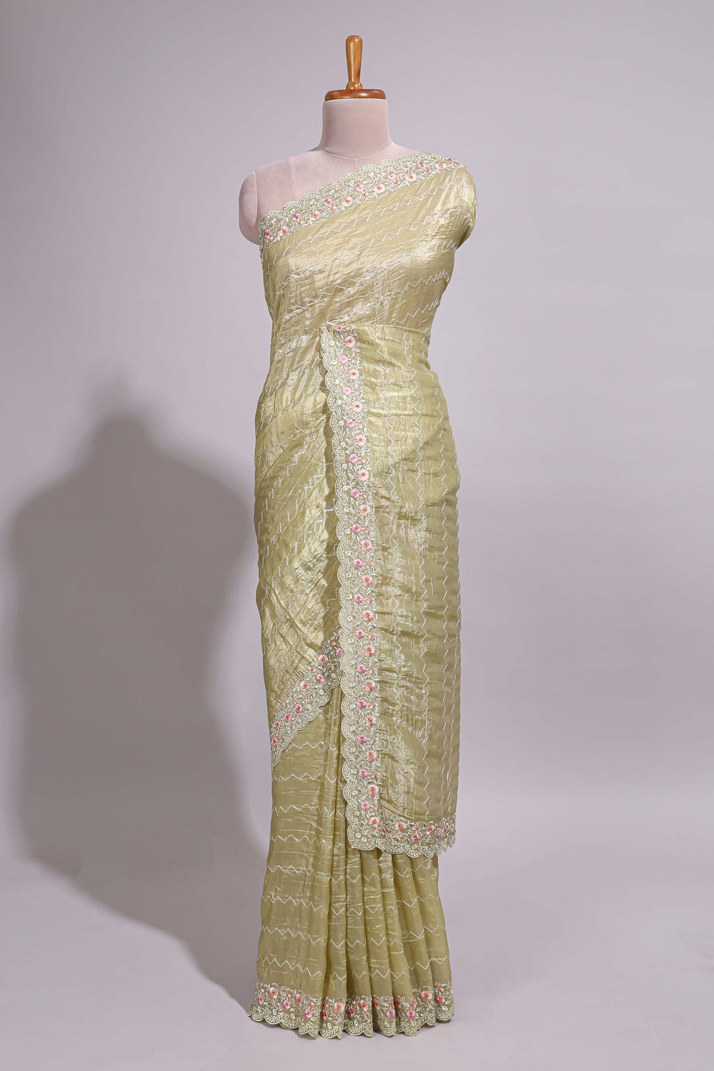 Pastel yellow organza saree featuring delicate floral embroidery intricate lace detailing on the border and pallu with a scalloped finishing along with matching blouse