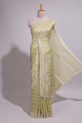 Pastel yellow organza saree featuring delicate floral embroidery intricate lace detailing on the border and pallu with a scalloped finishing along with matching blouse