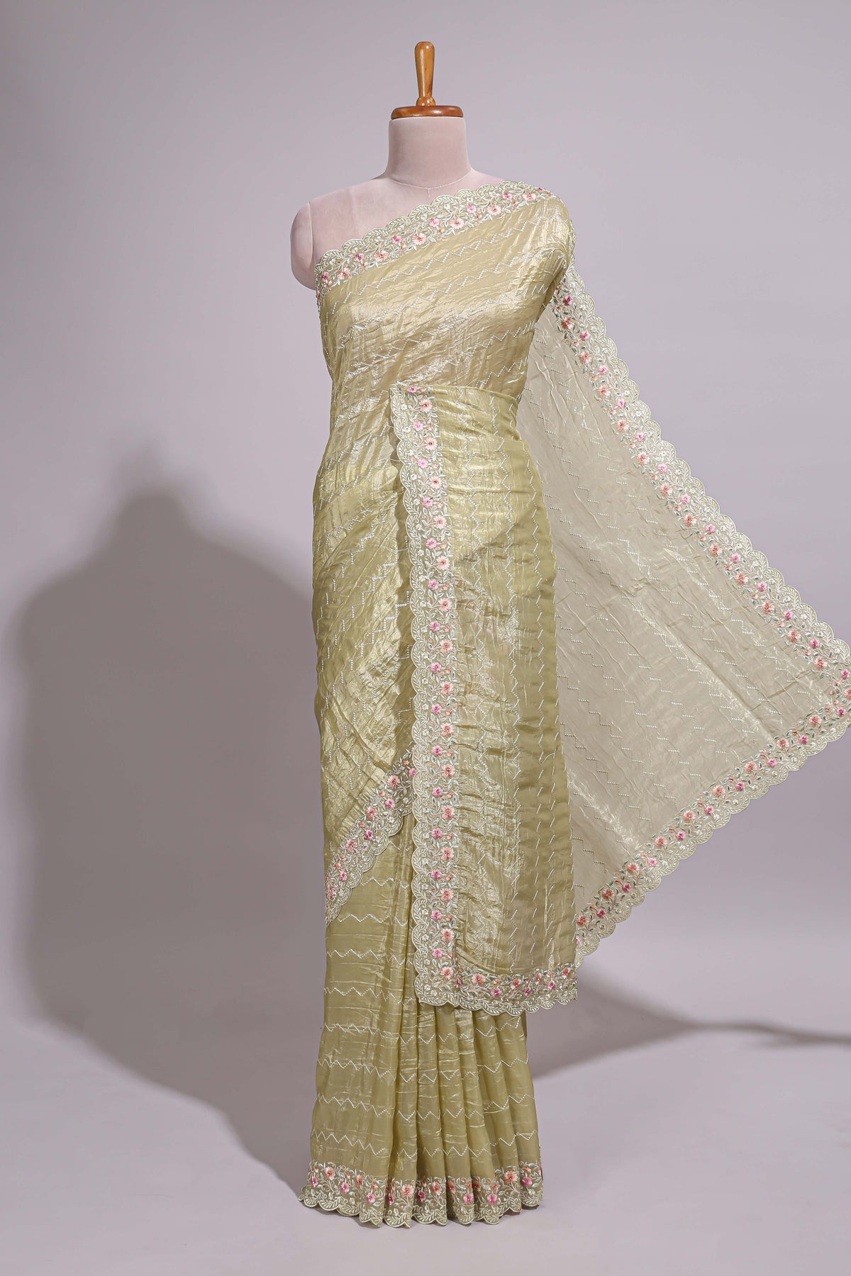 Pastel yellow organza saree featuring delicate floral embroidery intricate lace detailing on the border and pallu with a scalloped finishing along with matching blouse