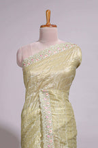 Pastel yellow organza saree featuring delicate floral embroidery intricate lace detailing on the border and pallu with a scalloped finishing along with matching blouse