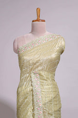 Pastel yellow organza saree featuring delicate floral embroidery intricate lace detailing on the border and pallu with a scalloped finishing along with matching blouse
