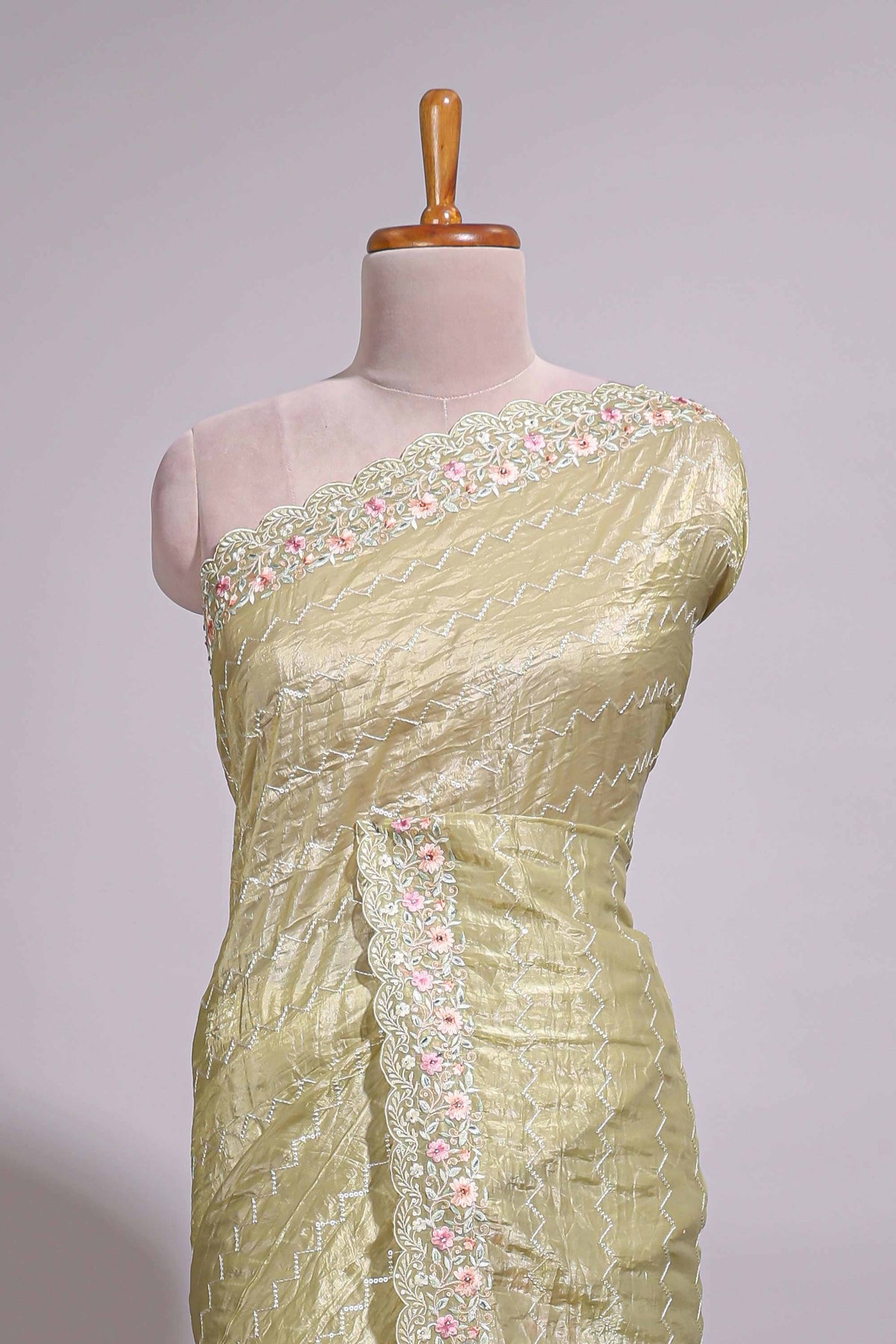 Pastel yellow organza saree featuring delicate floral embroidery intricate lace detailing on the border and pallu with a scalloped finishing along with matching blouse