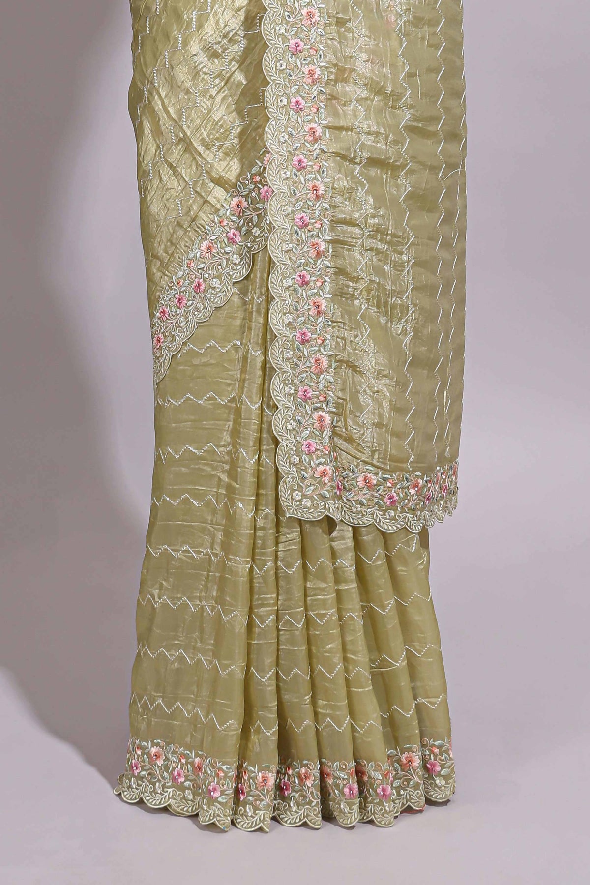 Pastel yellow organza saree featuring delicate floral embroidery intricate lace detailing on the border and pallu with a scalloped finishing along with matching blouse