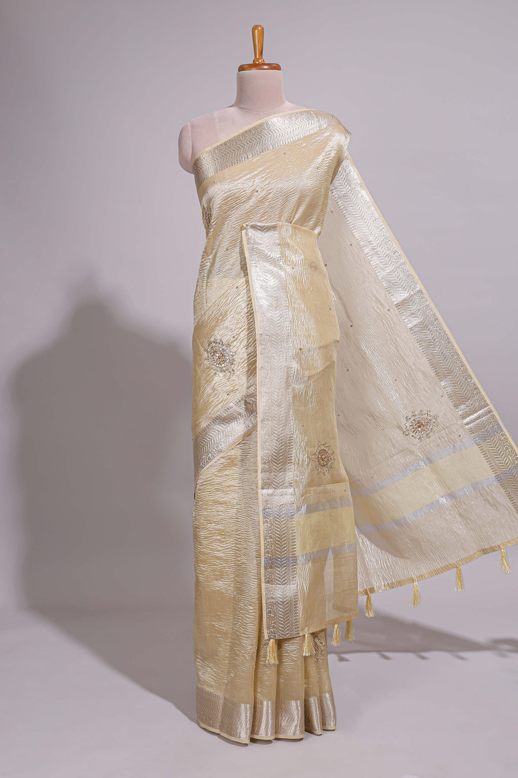 Cream organza saree featuring delicate floral embroidery intricate with silver  border along with blouse
