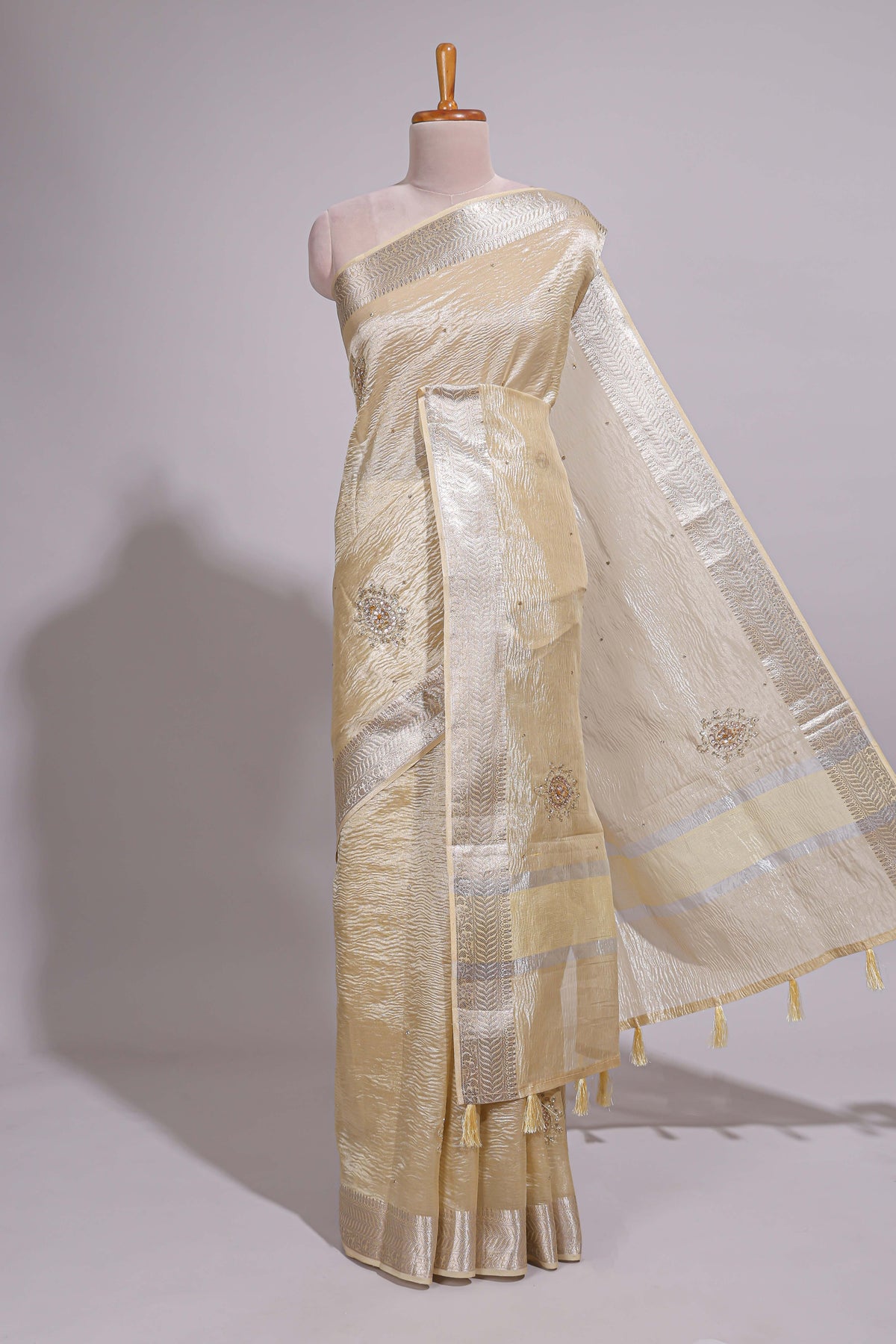 Cream organza saree featuring delicate floral embroidery intricate with silver  border along with blouse
