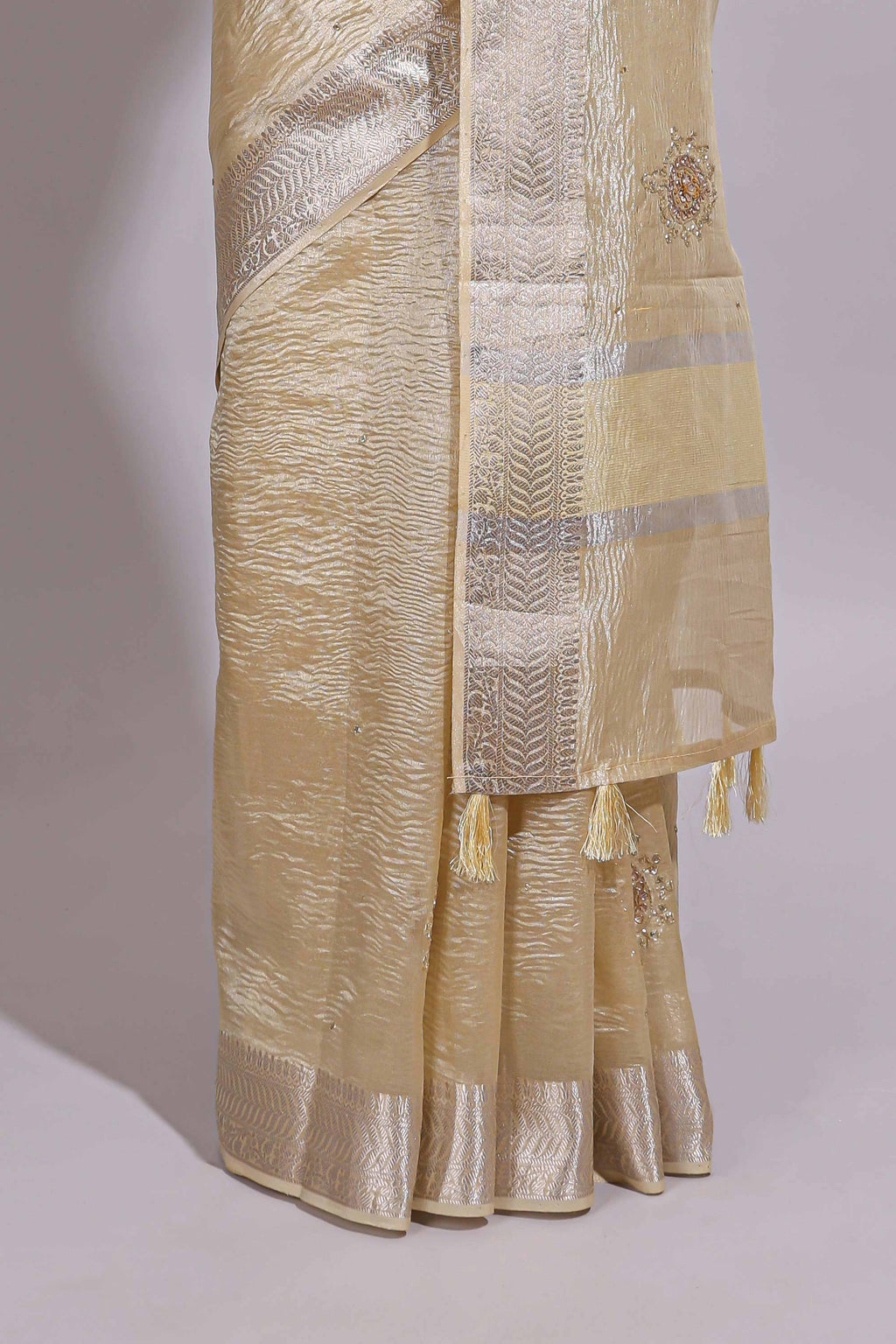 Cream organza saree featuring delicate floral embroidery intricate with silver  border along with blouse