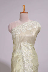 Pastel ivory organza saree with delicate floral embroidery intricate lace border and scalloped pallu detailing