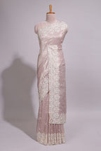 Soft blush pink organza saree with delicate floral embroidery intricate lace border and scalloped pallu detailing
