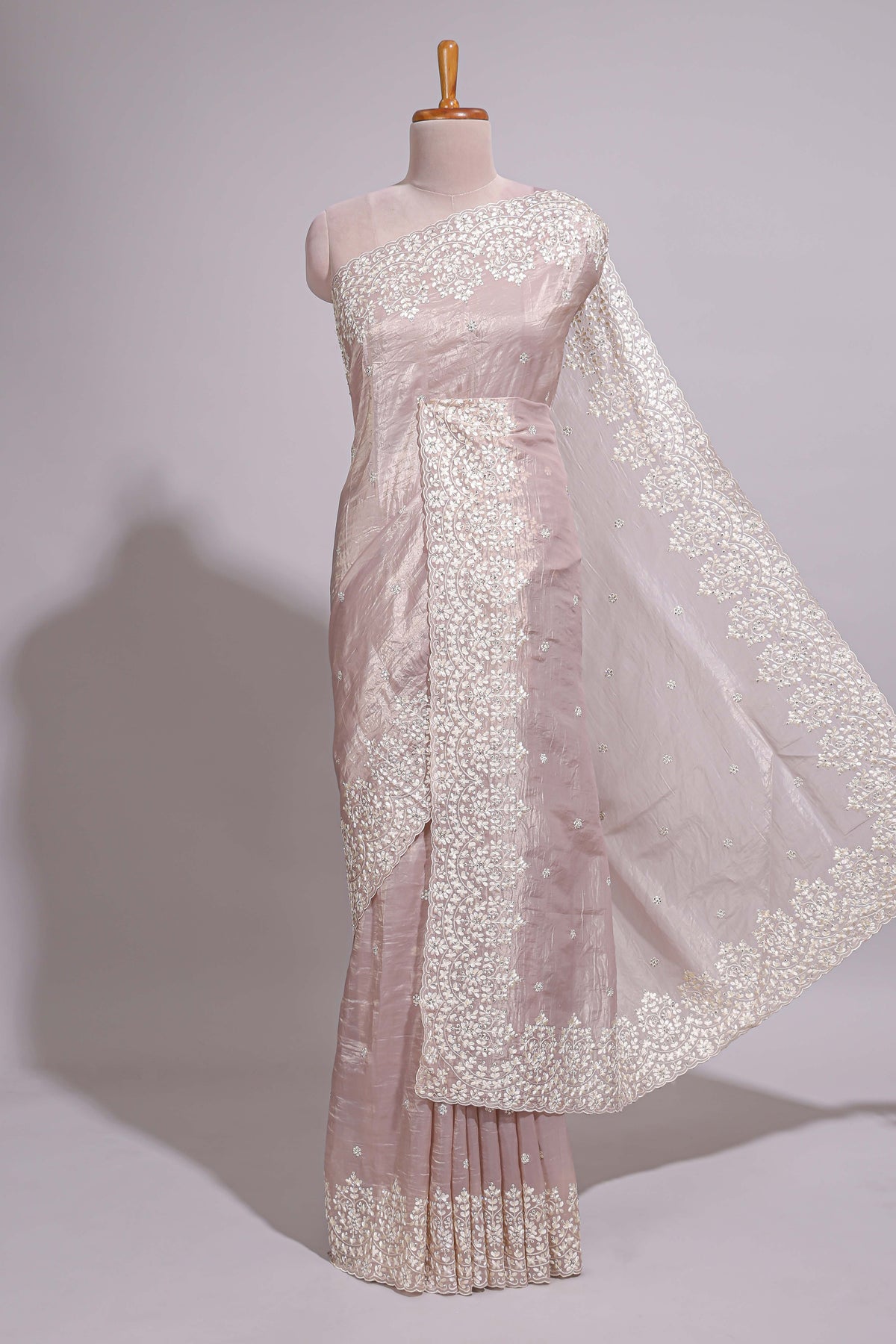 Soft blush pink organza saree with delicate floral embroidery intricate lace border and scalloped pallu detailing