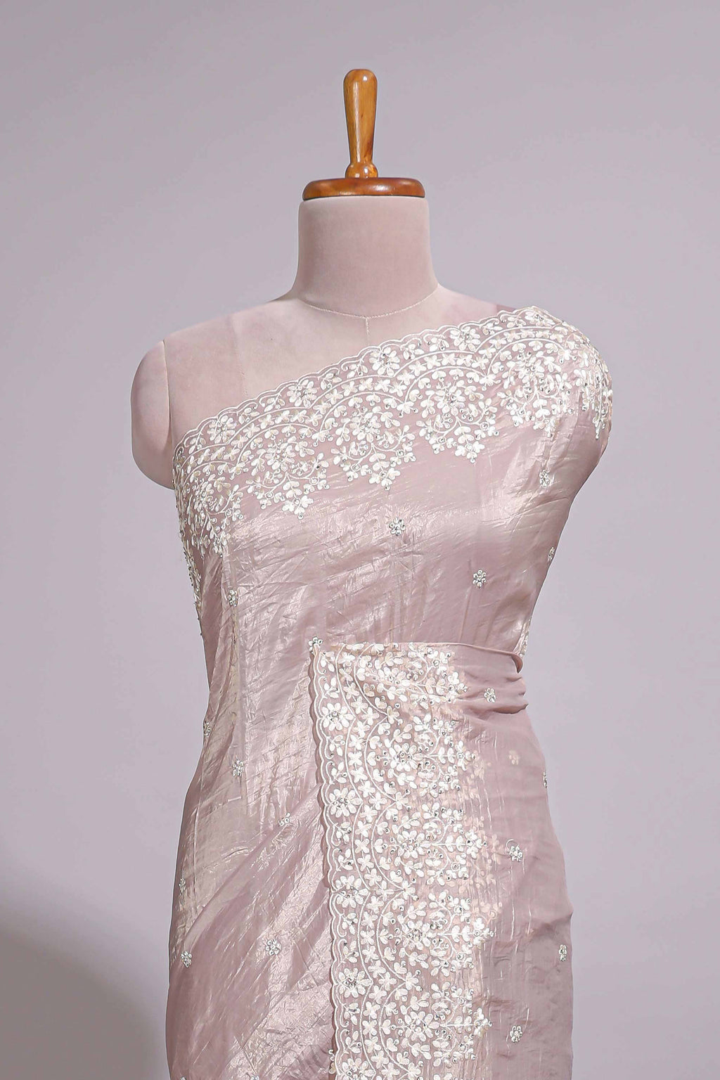 Soft blush pink organza saree with delicate floral embroidery intricate lace border and scalloped pallu detailing