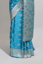 Blue shade floral designed banarasi silk saree with self zari border and blouse