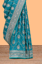 Blue floral designed banarasi silk saree with self floral border and matching blouse