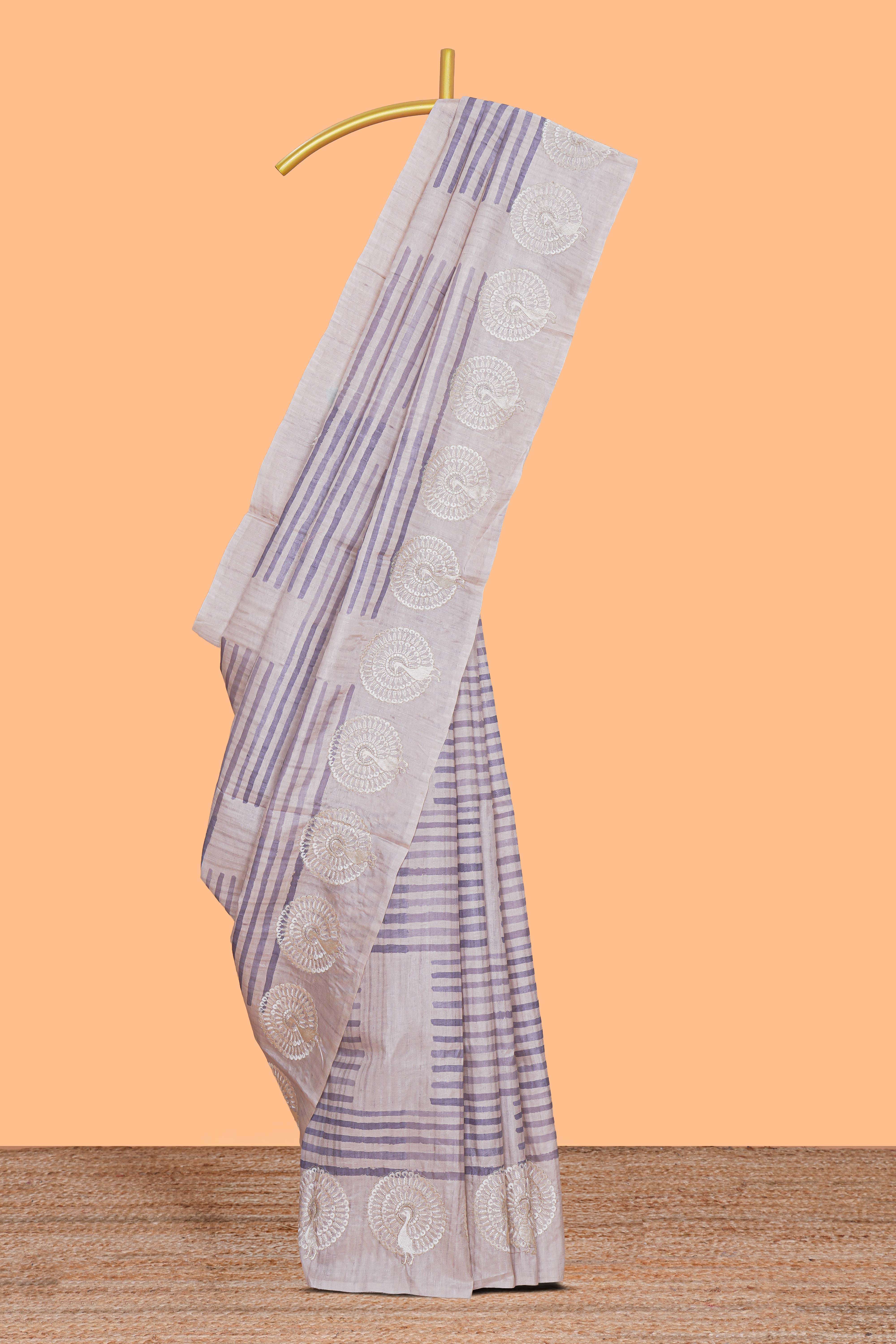 Off white striped design raw silk saree with self peacock design embroidery border and matching checked blouse