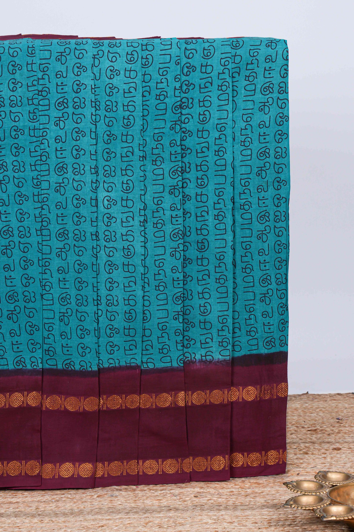 Turquiose blue tamil script print sungudi cotton saree with contrast zari bentex border and pallu