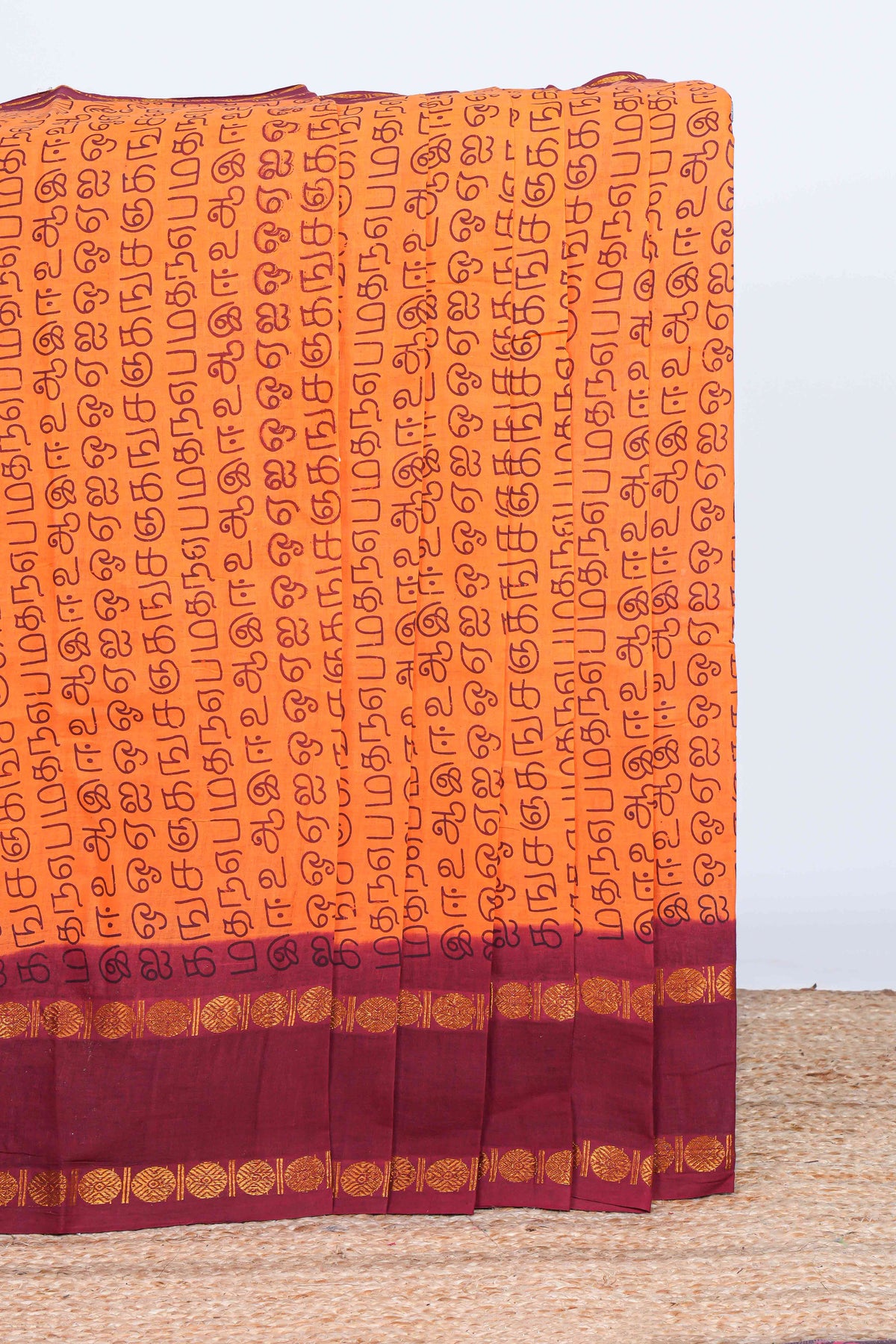Orange tamil script print sungudi cotton saree with contrast zari bentex border and pallu