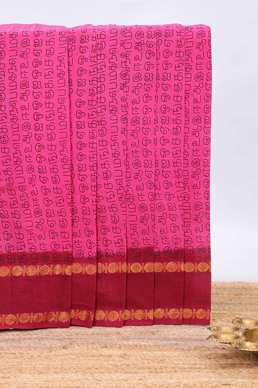 Pink tamil letters print sungudi cotton saree with contrast border and striped pallu