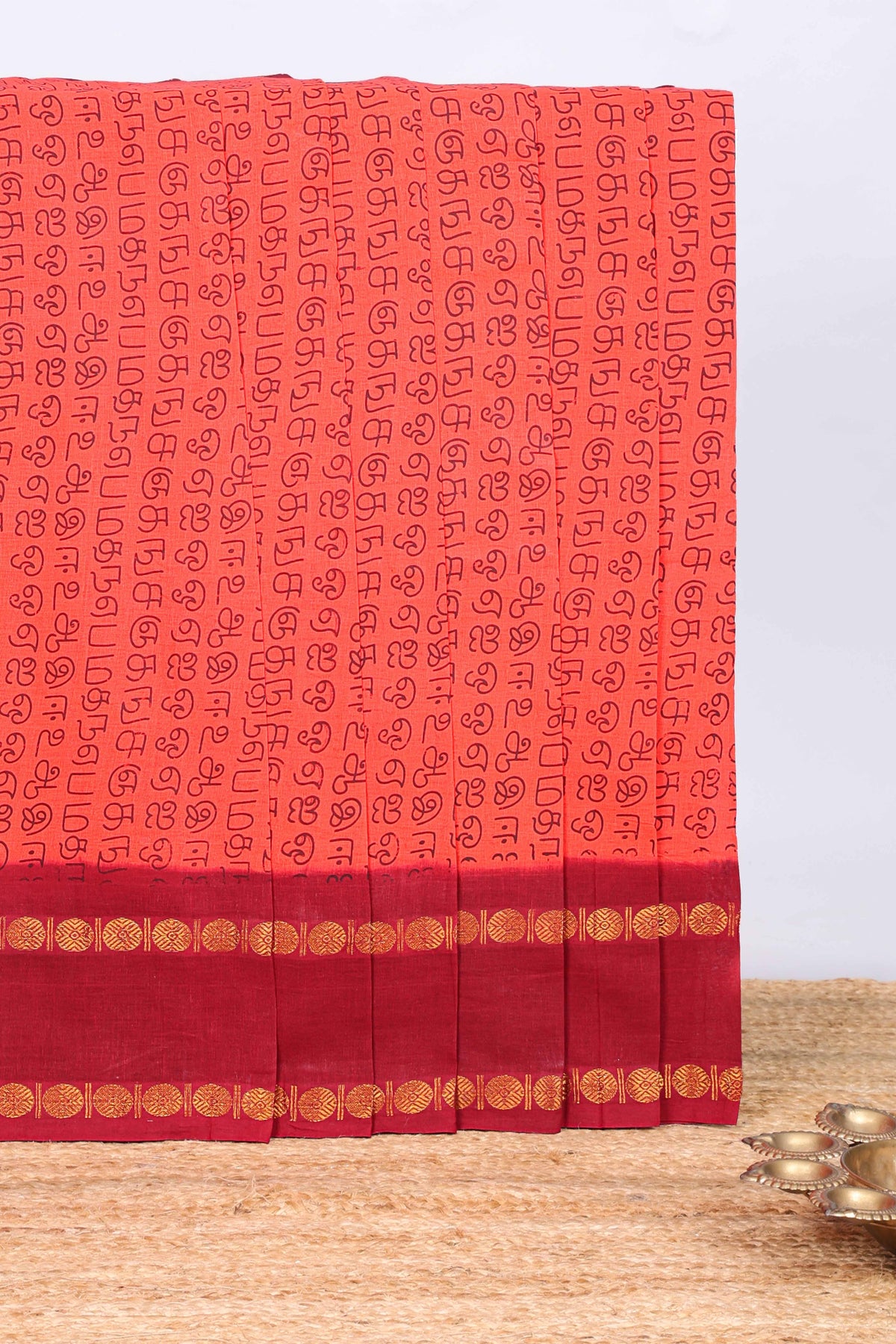 Peach tamil letters print sungudi cotton saree with contrast border and striped pallu