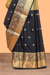 Black floral butta detailed Semi Soft Silk Saree with rich gold floral zari borders along with matching blouse