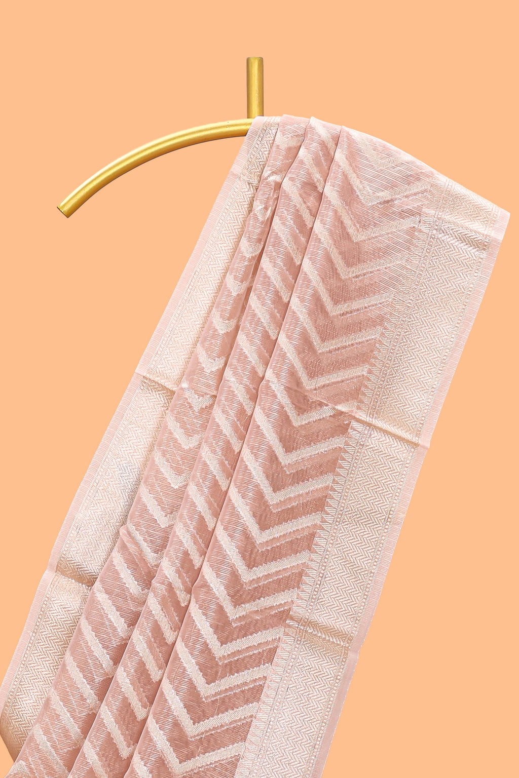 Peach color geometric design art tissue saree with contrast zari border and matching blouse