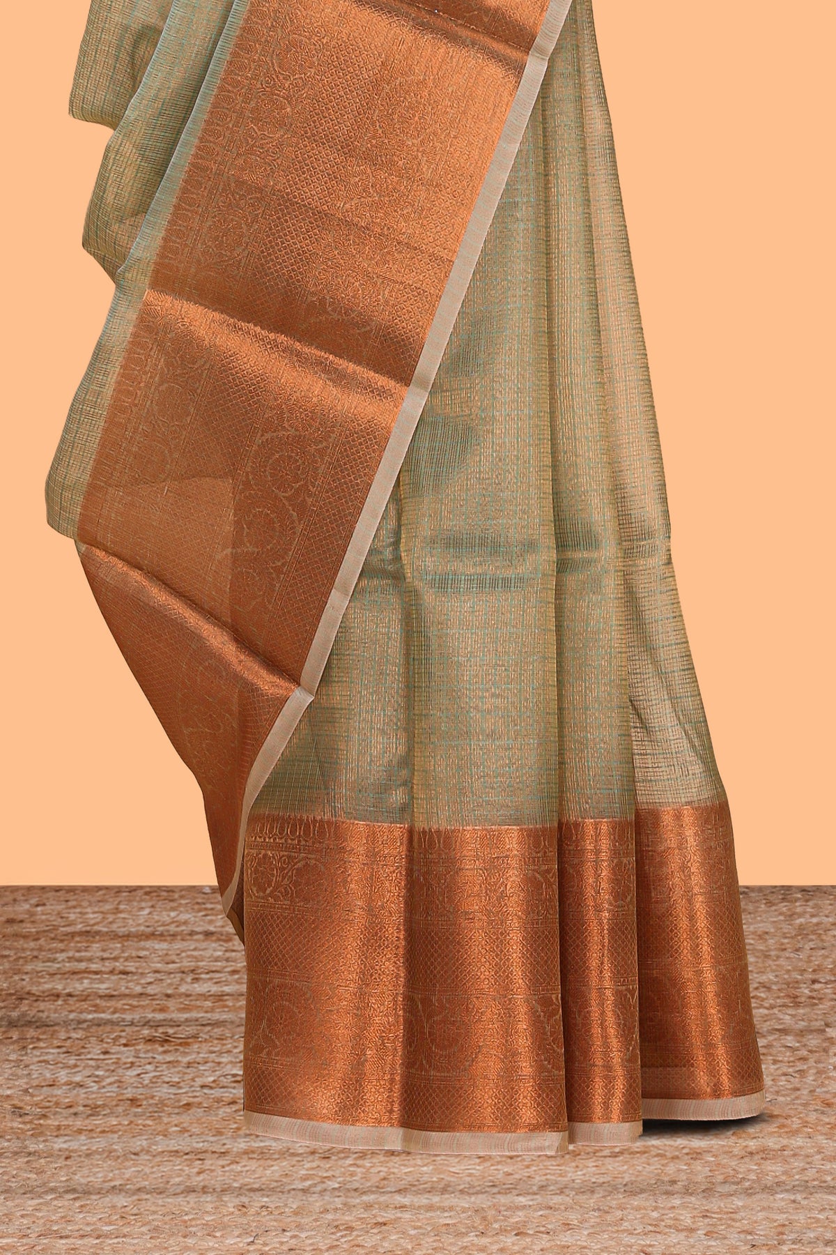 Muted green checked art tissue saree with contrast rust orange border and blouse