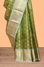 Green butta designs and striped art tissue saree with contrast zari border and blouse