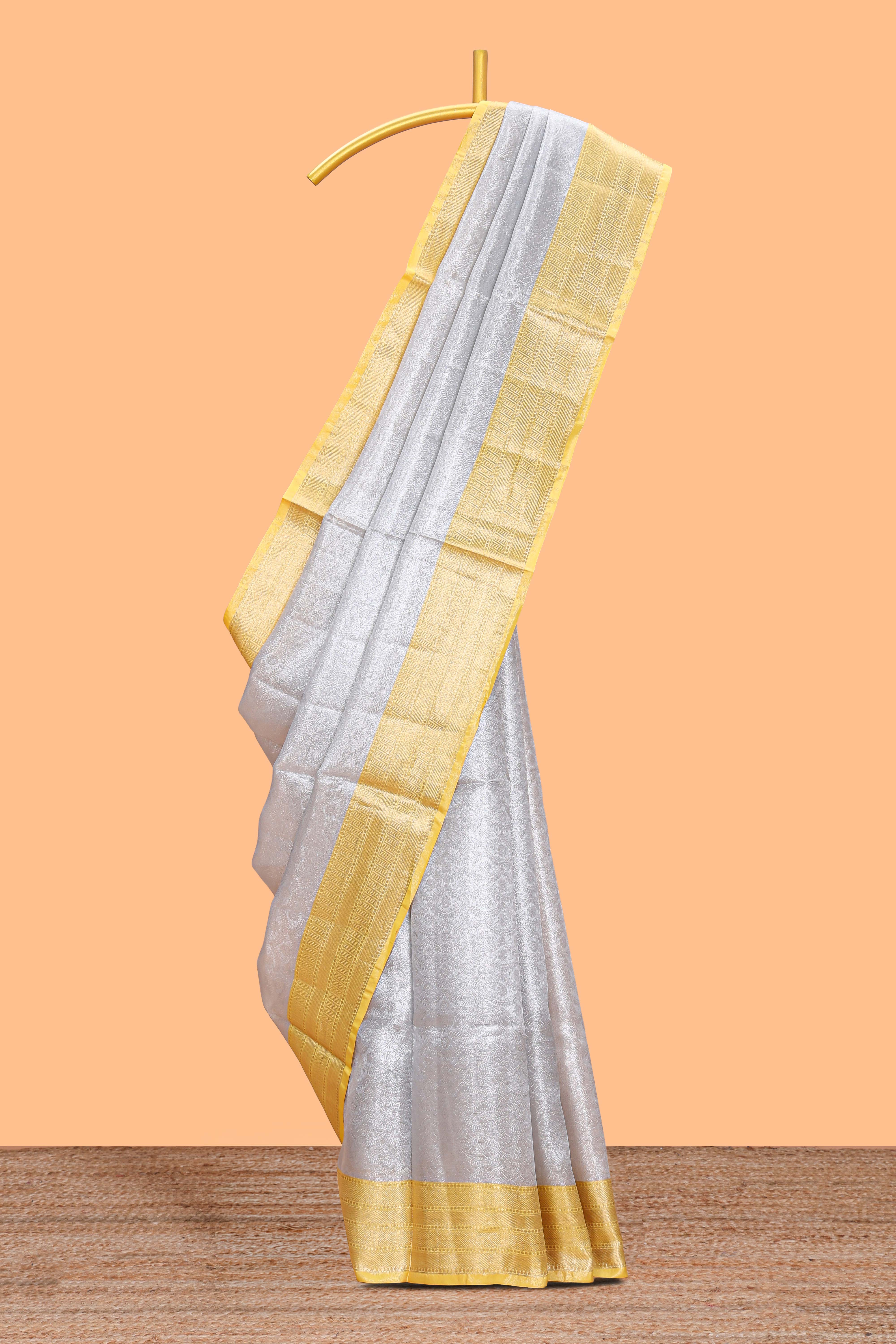 Silver zari motifs art tissue saree with gold contrast border and blouse