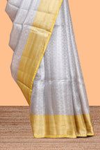 Silver zari motifs art tissue saree with gold contrast border and blouse