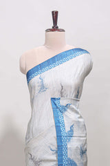 Cream peacock motifs tussar saree with contrast blue border and peacock printed pallu