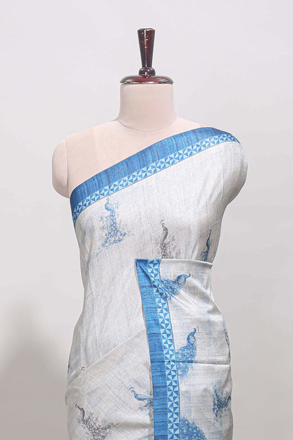 Cream peacock motifs tussar saree with contrast blue border and peacock printed pallu