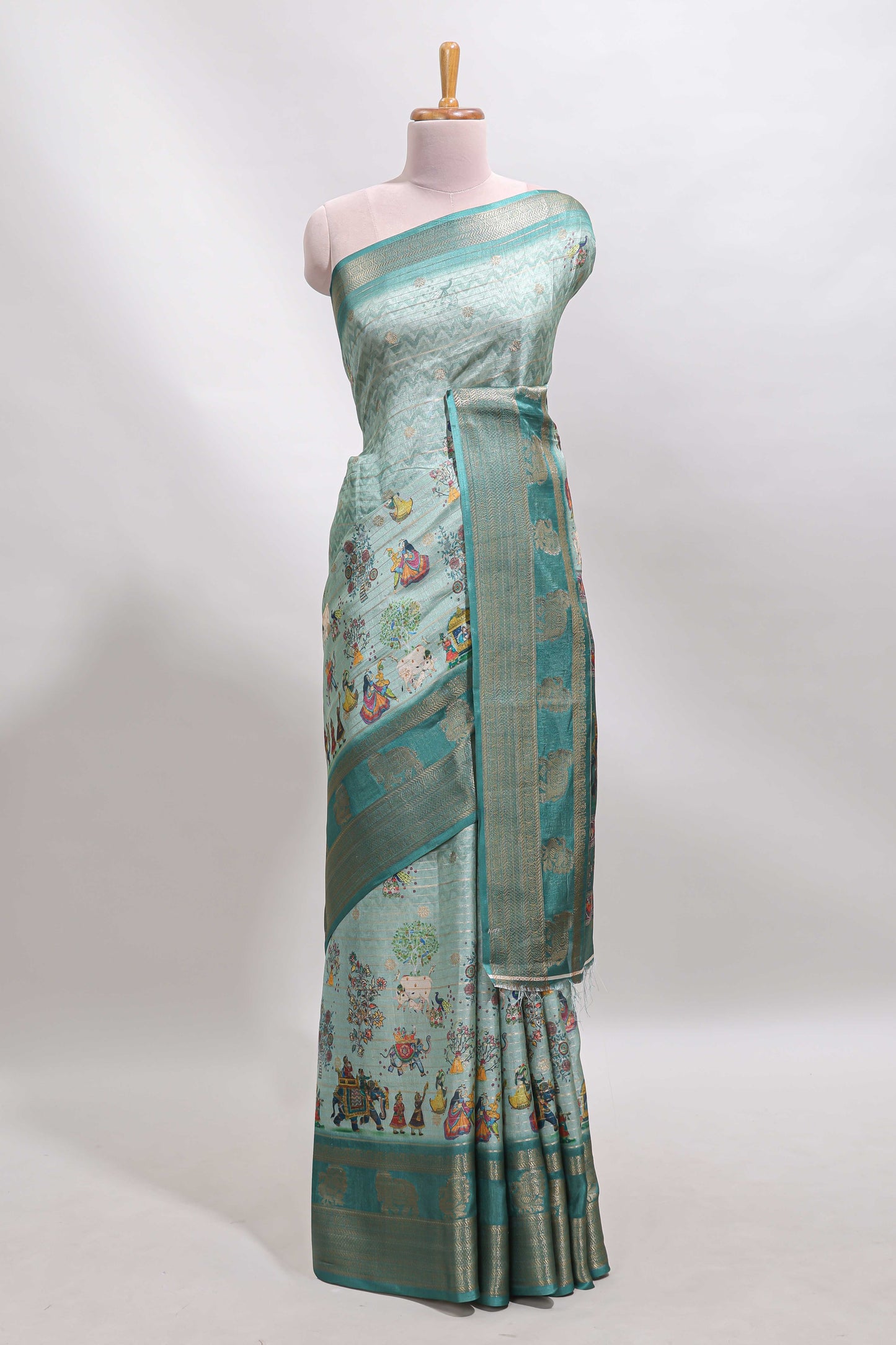 Turquoise green pichwai print tussar saree with contrast zari border and matching blouse