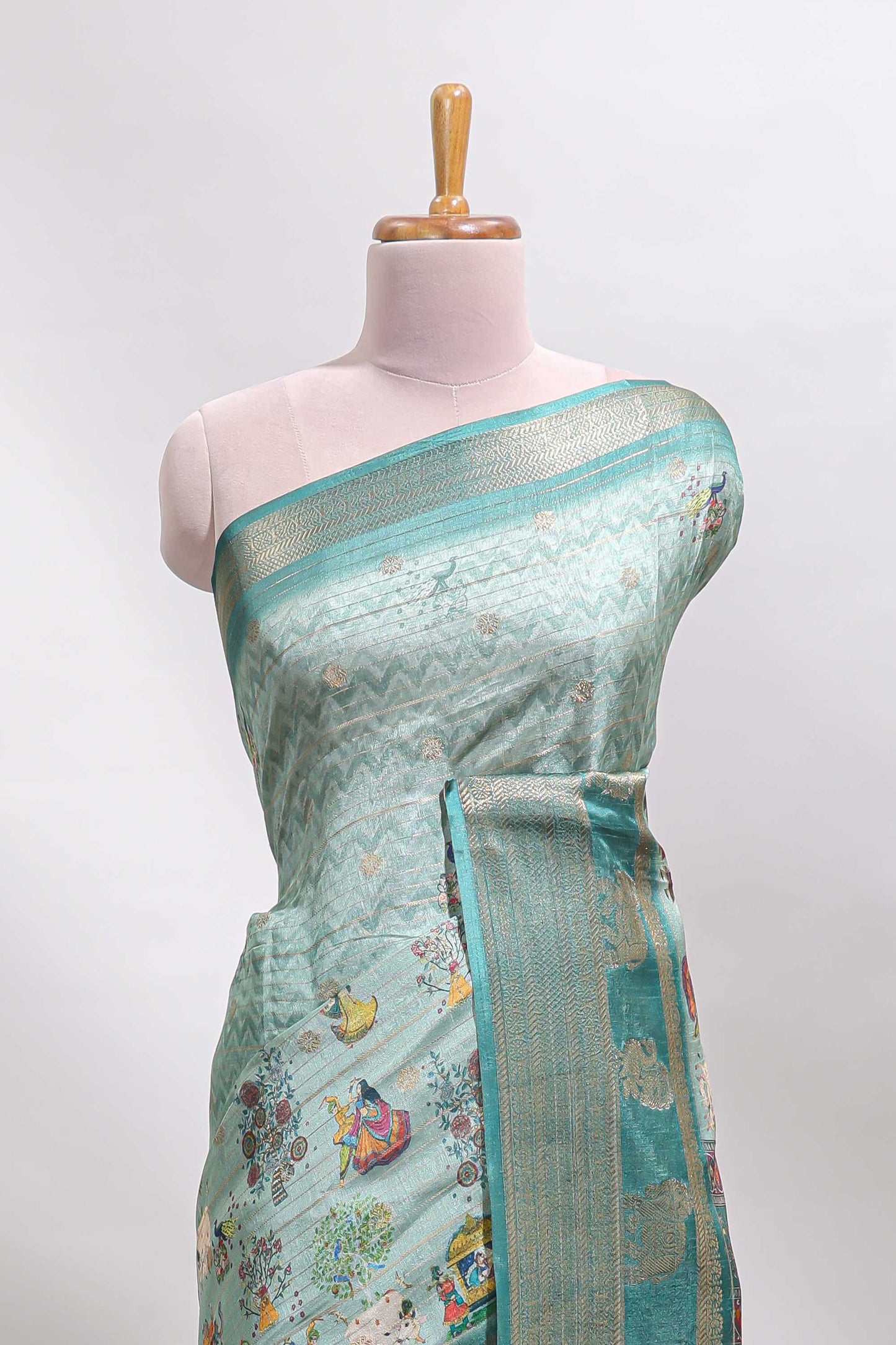 Turquoise green pichwai print tussar saree with contrast zari border and matching blouse