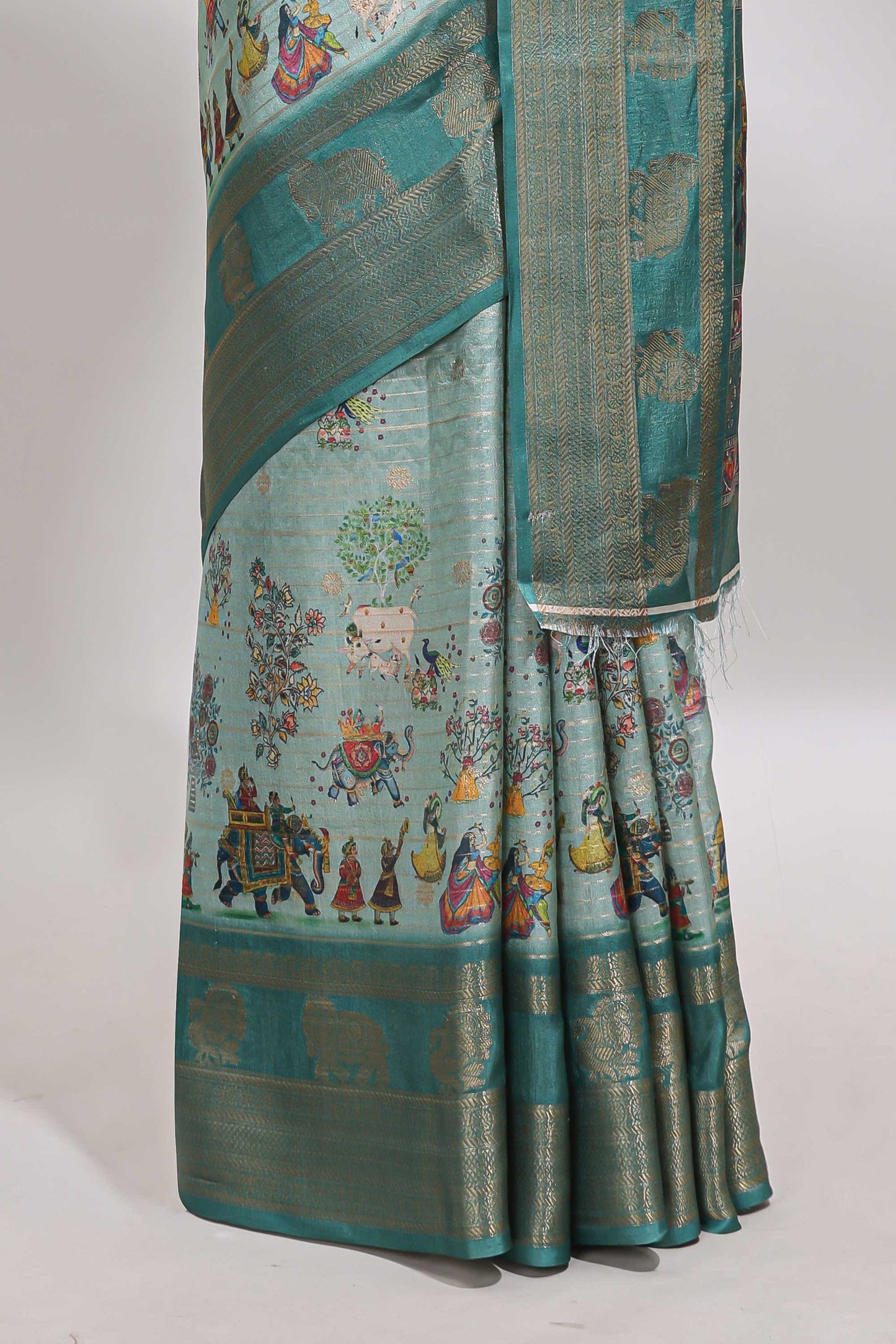 Turquoise green pichwai print tussar saree with contrast zari border and matching blouse