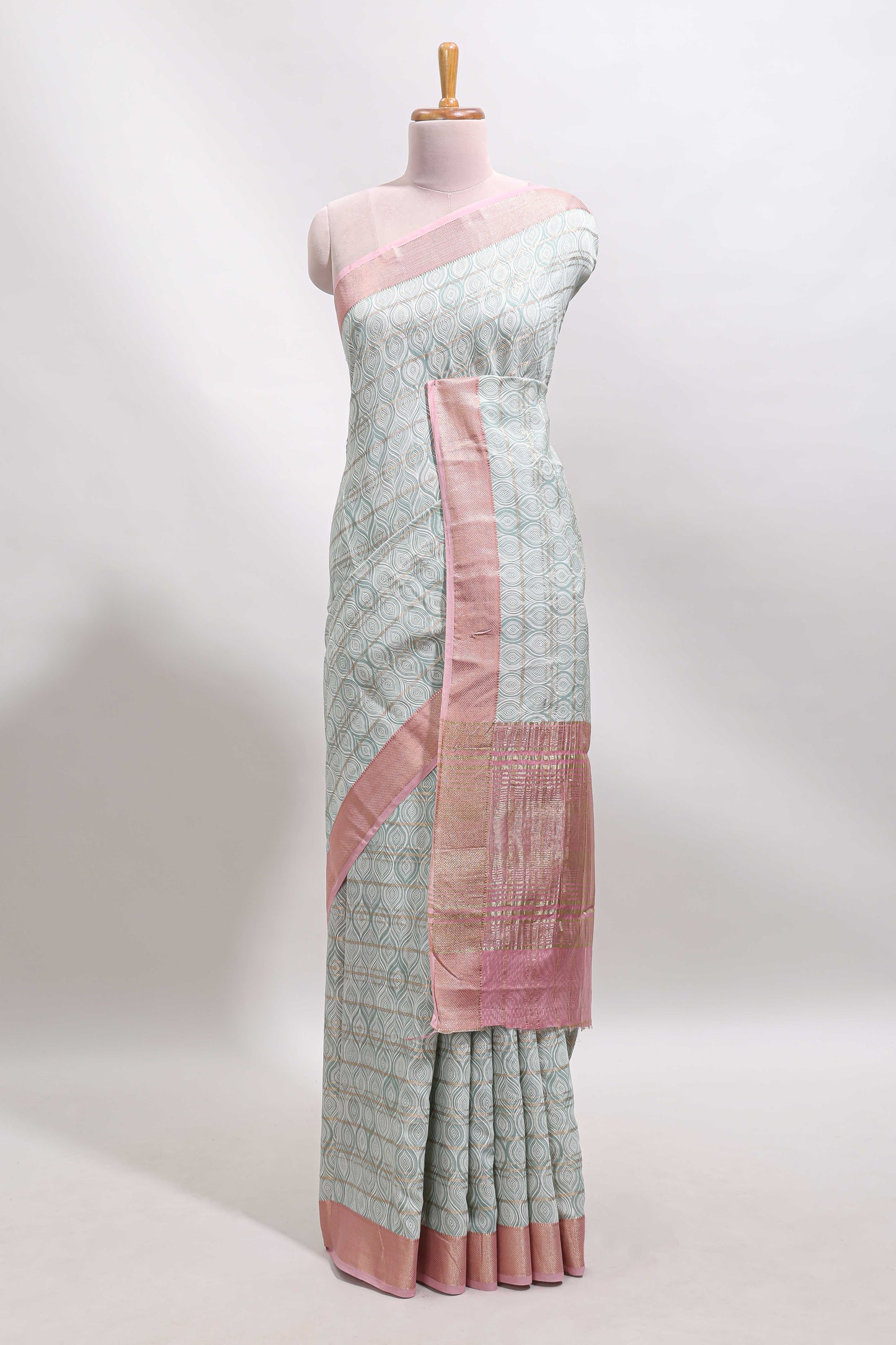 Green geometric design tussar saree with contrast zari border and striped blouse