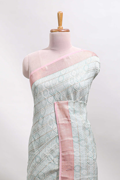 Green geometric design tussar saree with contrast zari border and striped blouse