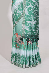 Green Tussar saree with a floral body featuring bird motifs a printed pallu with tassels and a matchingfloral blouse piece