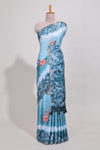 Blue Tussar saree with a floral body featuring bird motifs a printed pallu with tassels and a matchingfloral blouse piece
