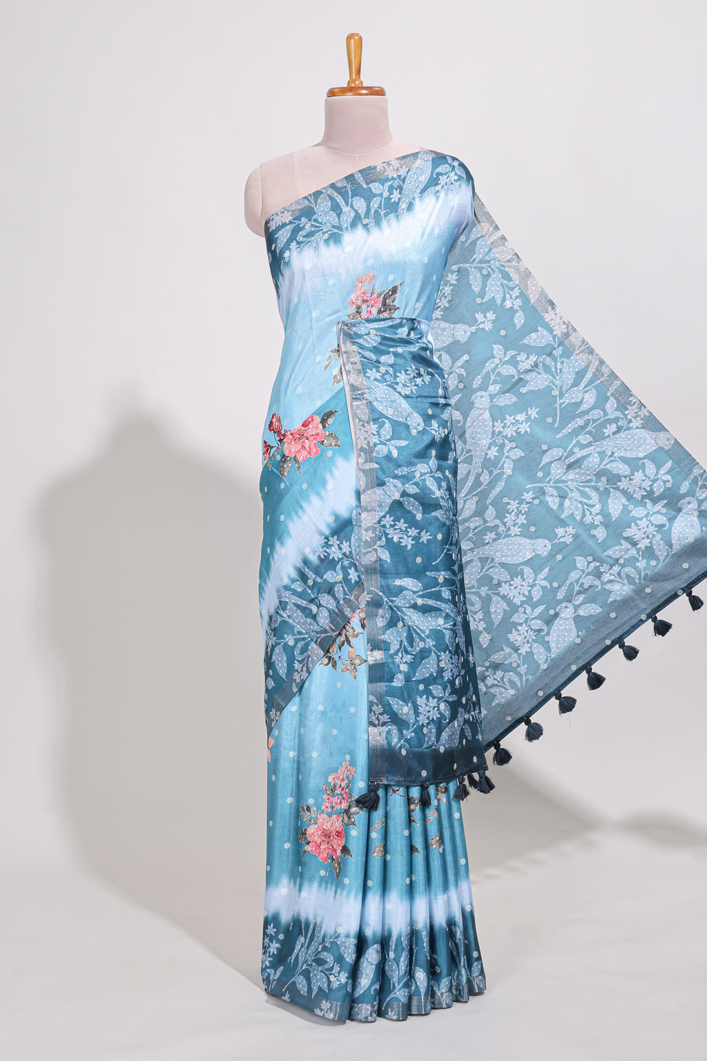 Blue Tussar saree with a floral body featuring bird motifs a printed pallu with tassels and a matching  floral blouse piece