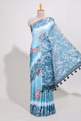 Blue Tussar saree with a floral body featuring bird motifs a printed pallu with tassels and a matchingfloral blouse piece