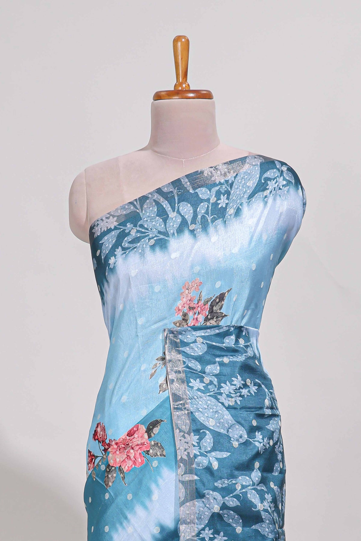 Blue Tussar saree with a floral body featuring bird motifs a printed pallu with tassels and a matching  floral blouse piece