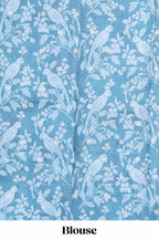 Blue Tussar saree with a floral body featuring bird motifs a printed pallu with tassels and a matching  floral blouse piece