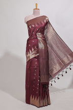 Maroon shimmering zari tussar saree with zari detailing temple pattern borders , and a rich zari pallu